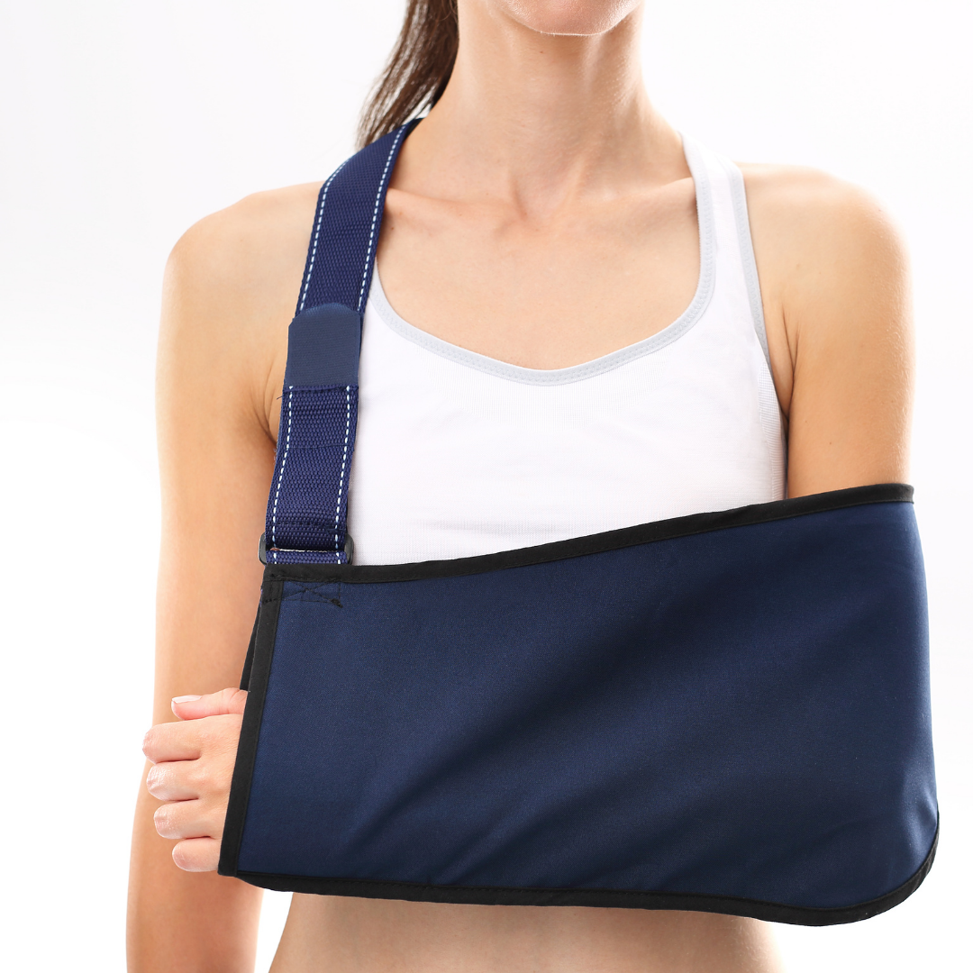 A person wearing a white tank top uses a navy blue arm sling to support their right arm.